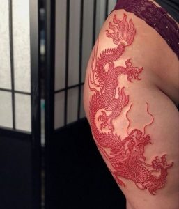 Red dragon tattoo on thigh